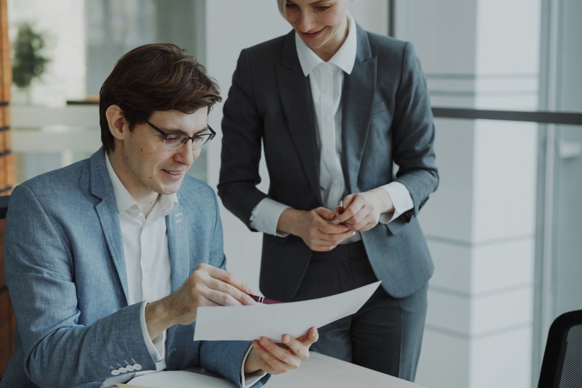 Two colleagues reviewing a document together in a modern office