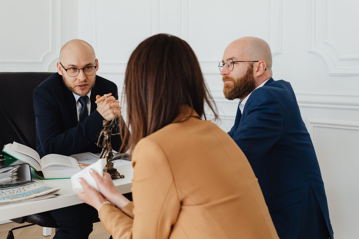 A solicitor in a meeting with two colleagues at a white desk