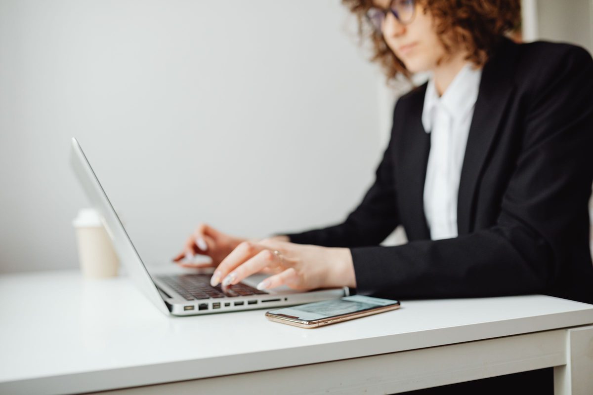 A lawyer working on a laptop at a white desk